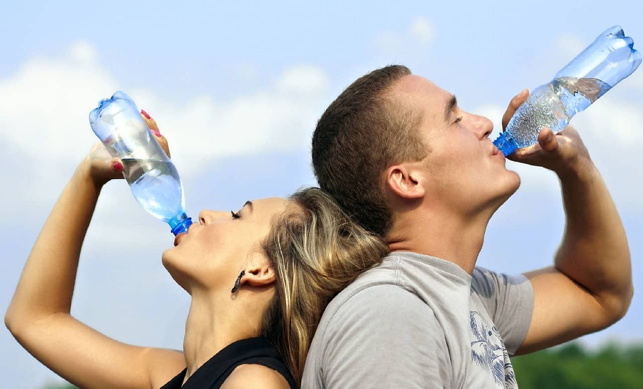 Stay hydrated while running in the Heat - Drinking water from bottles during the run.