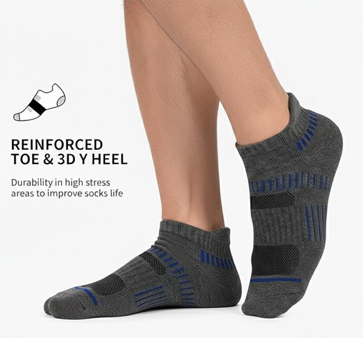 A close-up of a man's feet wearing grey Cooplus ankle socks with blue accents, highlighting the reinforced toe and 3D Y-heel design for durability and arch support.
