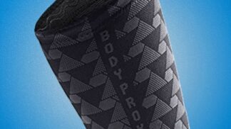 A black neoprene compression sleeve designed for hamstring support, featuring a textured, wave-patterned exterior with the "BodyProx" logo in white lettering and "Targeted compression for hamstring" text in yellow. The sleeve is shown angled against a blue background, highlighting its flexible, ergonomic fit for athletic recovery and injury prevention.